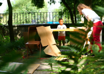 A young boy standing outdoors, talking to an adult